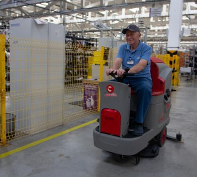 Profesjonalny pracownik firmy The Cleaning Pro Group (CPG) w specjalistycznym kombinezonie ochronnym czyści zaawansowane urządzenia produkcyjne z kurzu, tłuszczu i osadów przemysłowych.